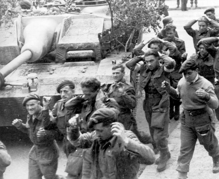 Zajatí britští výsadkáři, kteří statečně bojovali proti odhodlaně postupujícímu protivníkovi u Arnhemu. Za nimi německé útočné dělo StuG. 40. Foto sbírka VHÚ.