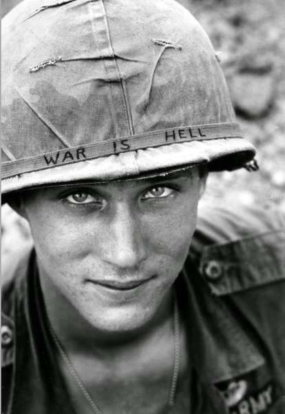 An-American-soldier-wears-a-hand-lettered-War-Is-Hell-slogan-on-his-helmet,-Vietnam,-1965