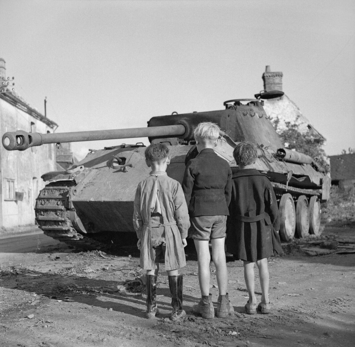 Three_French_boys_looking_at_a_knocked-out_German_Panther_tank_in_the_Falaise_pocket,_Normandy,_25_August_1944._B9665