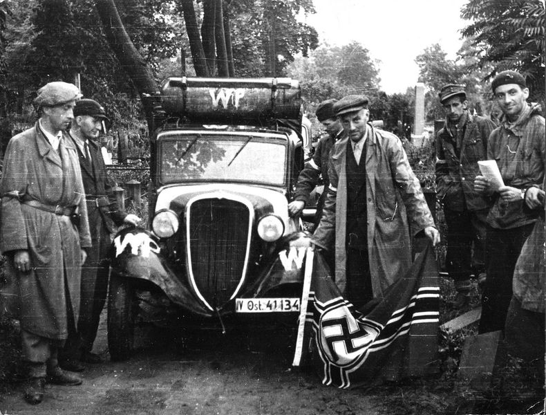 1. srpen 1944 krátce před hodinou W. Četa Agaton praporu Pięść na evangelickém hřbitově. S vlajkou pózuje velitel praporu, major Alfons Kotowski „Okoń“