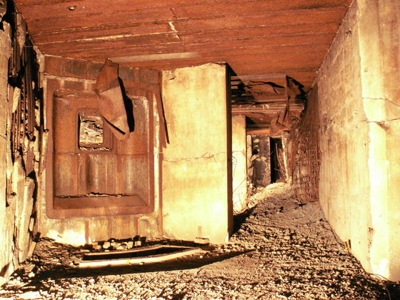 II-5 Pohled do horního patra srubu v roce 2008. Interér byl tehdy ještě plný sutě, trosek, odpadů a explodované munice.
